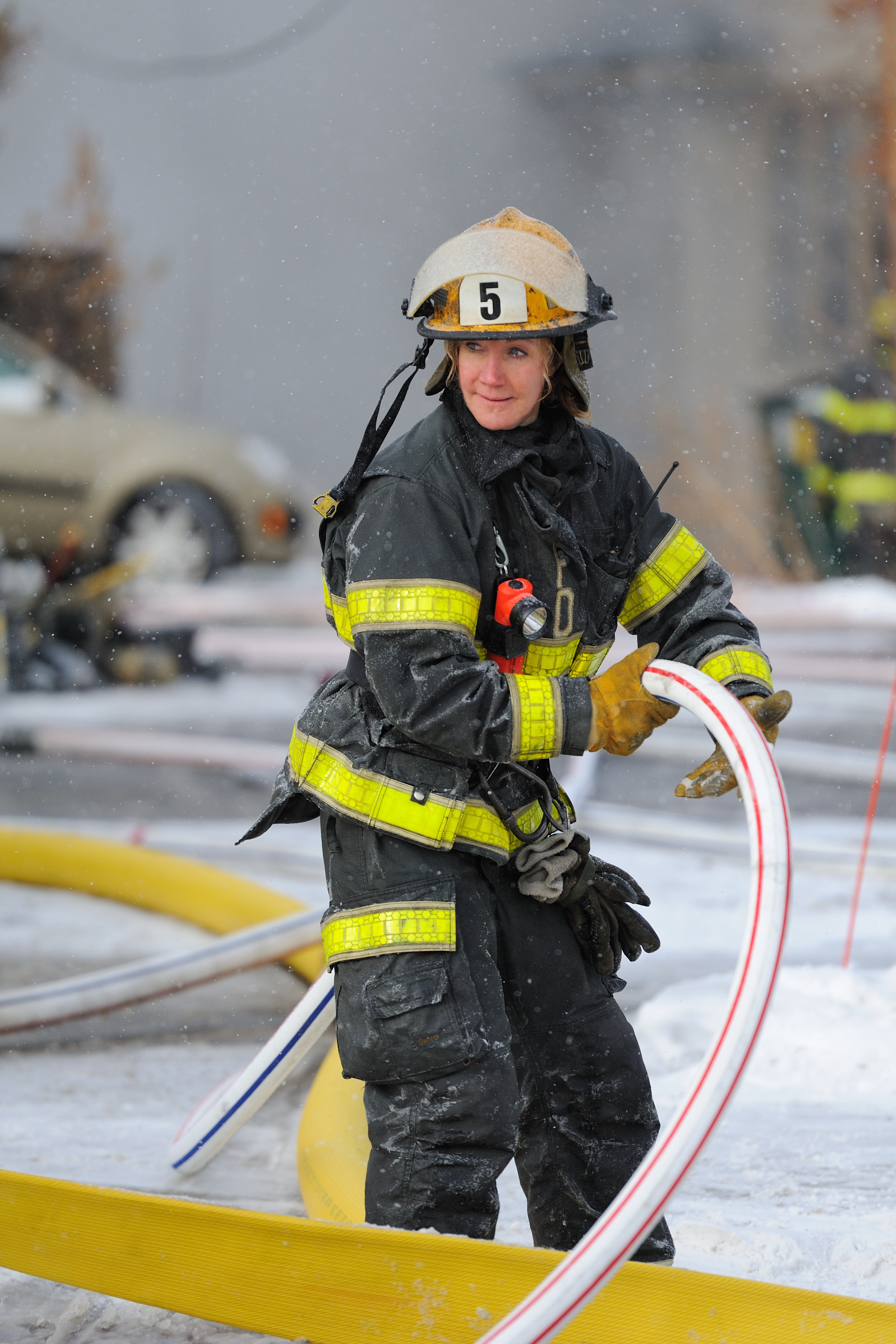 Woman firefighter with a fire hose