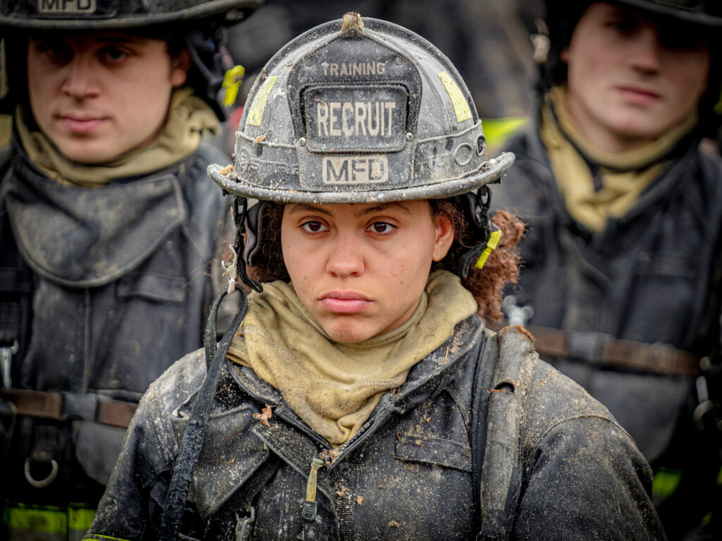 woman firefighter in foreground male firefighters in background